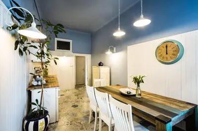 a dining room with a table and a clock on the wall at Apartment Bernardynska in Kraków