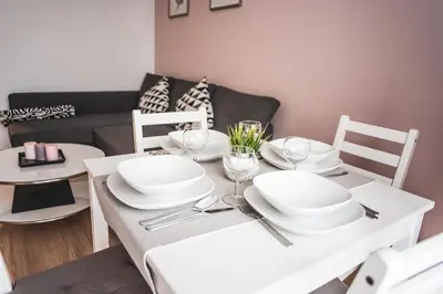 a dining room table with white plates and wine glasses at Przy Mocaku in Kraków