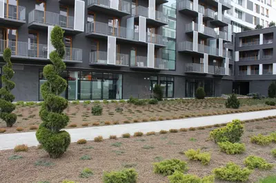 a garden in front of a apartment building at Przy Mocaku in Kraków