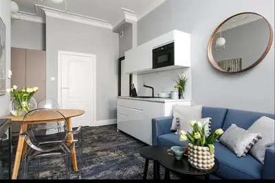 a living room with a blue couch and a table at Fragola Apartments Old Town in Kraków