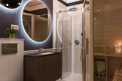 a bathroom with a shower and a sink and a mirror at Fragola Apartments Old Town in Kraków