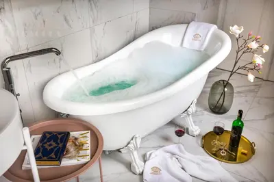 a bath tub filled with water in a bathroom at Fragola Apartments Old Town in Kraków
