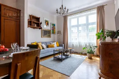 a living room with a blue couch and a table at Fragola Apartments Old Town in Kraków