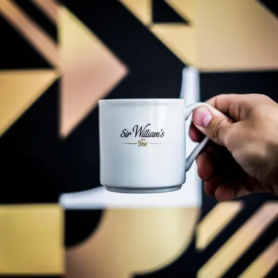 a person holding a white coffee mug in their hand at Zulian Aparthotel by Artery Hotels in Kraków