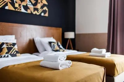 two beds with towels on them in a hotel room at Zulian Aparthotel by Artery Hotels in Kraków