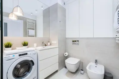 a bathroom with a washing machine and a toilet at Apartament Mateo Inn in Kraków