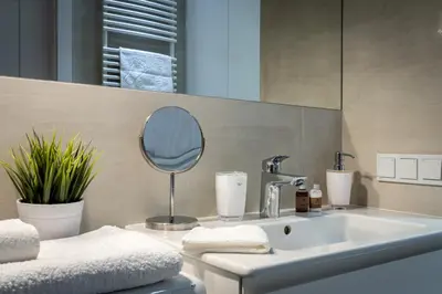 a bathroom with a sink and a mirror at Apartament Mateo Inn in Kraków