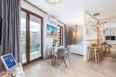 a small apartment with a bedroom and a table and chairs at Apartament Mateo Inn in Kraków