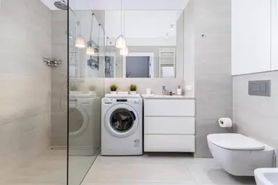 a bathroom with a washing machine and a sink at Apartament Mateo Inn in Kraków