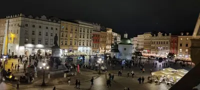 a group of people walking around a city at night at Apartment Łobzowska in Kraków