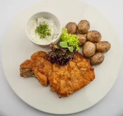 a white plate of food with meat and potatoes at Hotel Polski Pod Białym Orłem in Kraków