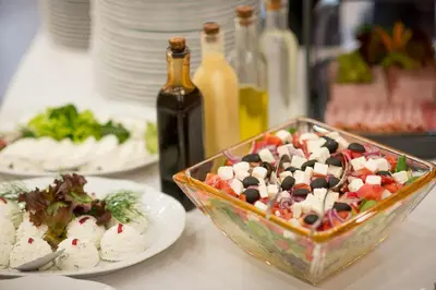 a table with plates of food and a bowl of salad at Hotel Polski Pod Białym Orłem in Kraków