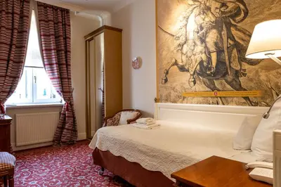a hotel room with a bed and a painting on the wall at Hotel Polski Pod Białym Orłem in Kraków