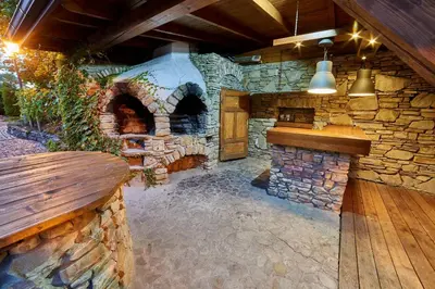 an outdoor kitchen with a stone oven in a house at Folwark Stara Winiarnia in Mszana Dolna