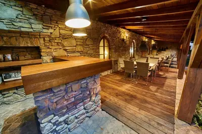 a bar in a restaurant with a stone wall at Folwark Stara Winiarnia in Mszana Dolna