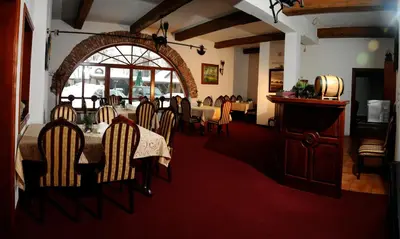 a dining room with a table and chairs in a restaurant at Folwark Stara Winiarnia in Mszana Dolna