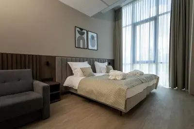 a bedroom with a bed and a chair and a window at Hotel Centrum Business in Kraków