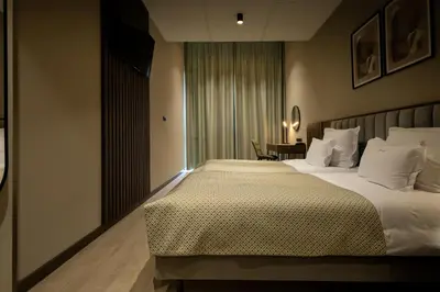 a hotel room with a large bed and a table at Hotel Centrum Business in Kraków