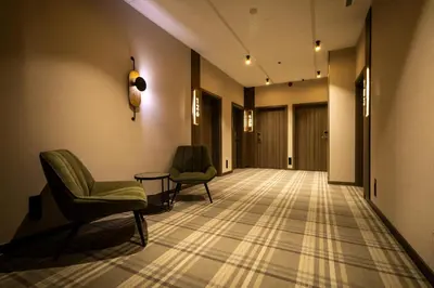 an empty hallway with two chairs and a table at Hotel Centrum Business in Kraków