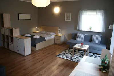 a small bedroom with a bed and a couch at Friendly Apartments - Krakow in Kraków