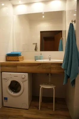 a bathroom with a sink and a washing machine at Friendly Apartments - Krakow in Kraków