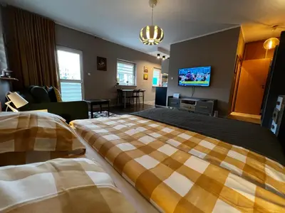 a hotel room with two beds and a flat screen tv at Friendly Apartments - Krakow in Kraków