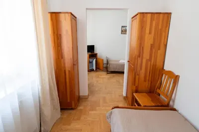 a bedroom with a bed and two wooden doors at Pokoje Gościnne Dom św. Szymona in Kraków