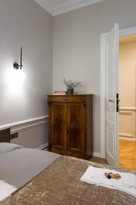 a bedroom with a bed and a wooden cabinet at apartament PAULOVE in Kraków