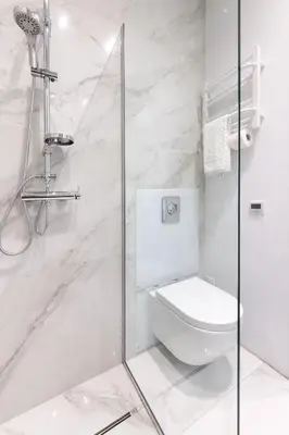 a bathroom with a toilet and a glass shower at apartament PAULOVE in Kraków