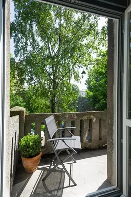 a chair sitting on a porch with a tree at apartament PAULOVE in Kraków