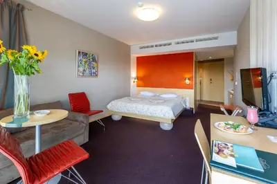 a hotel room with a bed and a couch at Niebieski Art Hotel & Spa in Kraków