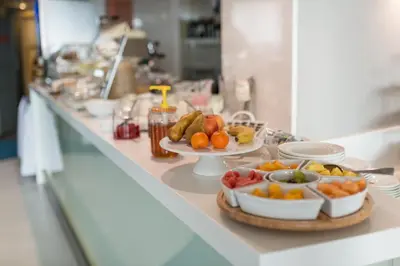 a buffet with plates of fruits and vegetables on a counter at Niebieski Art Hotel & Spa in Kraków