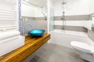 a bathroom with a blue bowl sink on a wooden counter at Kazimierz Friendhouse Apartments in Kraków