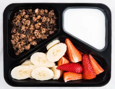 a lunch box with fruit and chocolate and raisins at Kazimierz Friendhouse Apartments in Kraków
