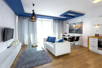 a living room with a white couch and a table at Kazimierz Friendhouse Apartments in Kraków
