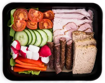 a lunch box with meat and vegetables and bread at Kazimierz Friendhouse Apartments in Kraków