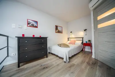 a bedroom with a bed and a dresser with red candles at Kazimierz Friendhouse Apartments in Kraków
