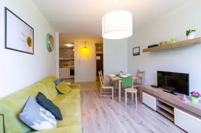 a living room with a couch and a dining room at Kazimierz Friendhouse Apartments in Kraków