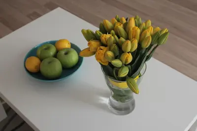 a vase of flowers and a bowl of fruit on a table at Apartment in Center in Kraków