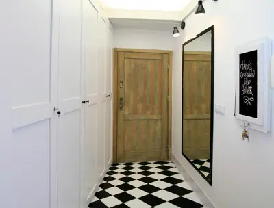 a hallway with a door and a checkered floor at Designer Apt in the heart of Kraków 4th floor no lift in Kraków