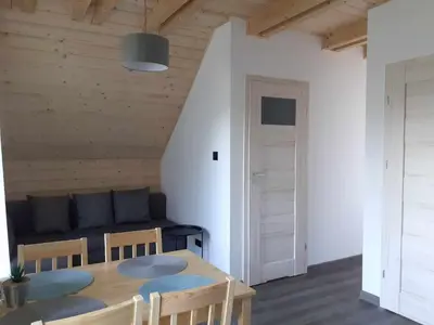 a room with a table and chairs and a couch at Agroturystyka Jagodowa Róża - Maria Farganus in Mszana Dolna