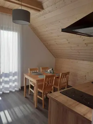 a kitchen and dining room with a table and chairs at Agroturystyka Jagodowa Róża - Maria Farganus in Mszana Dolna