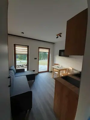 a kitchen and living room with a couch and a table at Agroturystyka Jagodowa Róża - Maria Farganus in Mszana Dolna