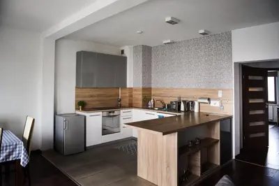 a kitchen with white cabinets and a wooden counter top at Apartament Myślenice in Myślenice