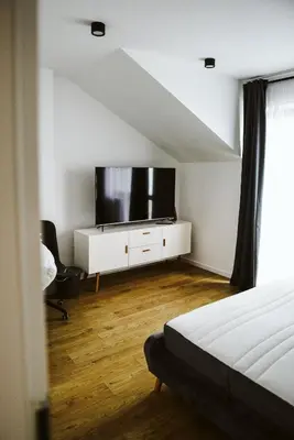 a bedroom with a flat screen tv on a white dresser at Apartament Myślenice in Myślenice