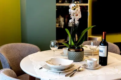 a white table with a bottle of wine and glasses at Verona Apartment 129 - 70m2, Terrace, Garage in Kraków