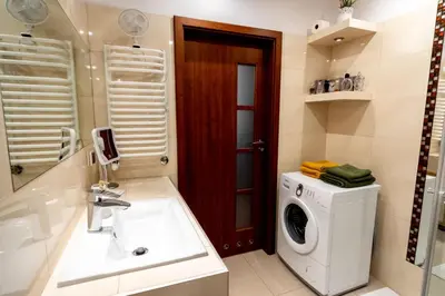 a bathroom with a washing machine and a sink at Verona Apartment 129 - 70m2, Terrace, Garage in Kraków