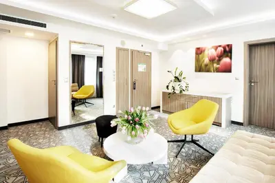 a lobby with yellow chairs and a table at Golden Tulip Krakow Kazimierz in Kraków