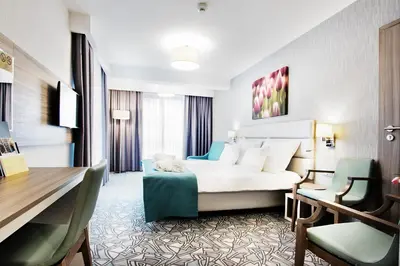 a hotel room with a bed and a desk at Golden Tulip Krakow Kazimierz in Kraków