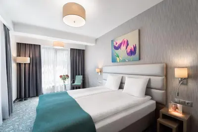 a hotel room with a bed and a window at Golden Tulip Krakow Kazimierz in Kraków